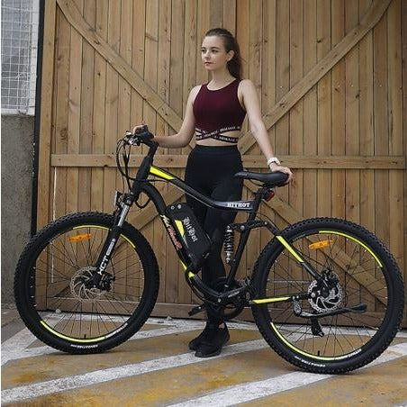 Yellow AddMotor HitHot H1 - Electric Mountain Bike - in front of barn door
