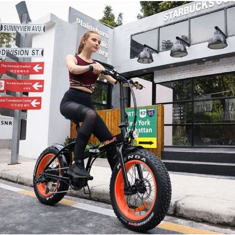Orange AddMotor Motan M150 - Folding Fat Tire Electric Bike - Female Rider on Street