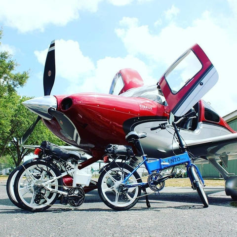 Enzo eBikes - Folding Electric Bike - Multiple in front of airplane