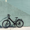 Image of Black Espin Flow - Electric Commuter Bike - Leaning against a wall